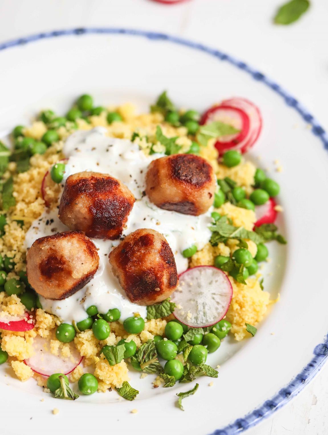 Turkey meatballs served alongside a lemon and mint couscous salad with peas and radishes, with a yogurt dipping sauce