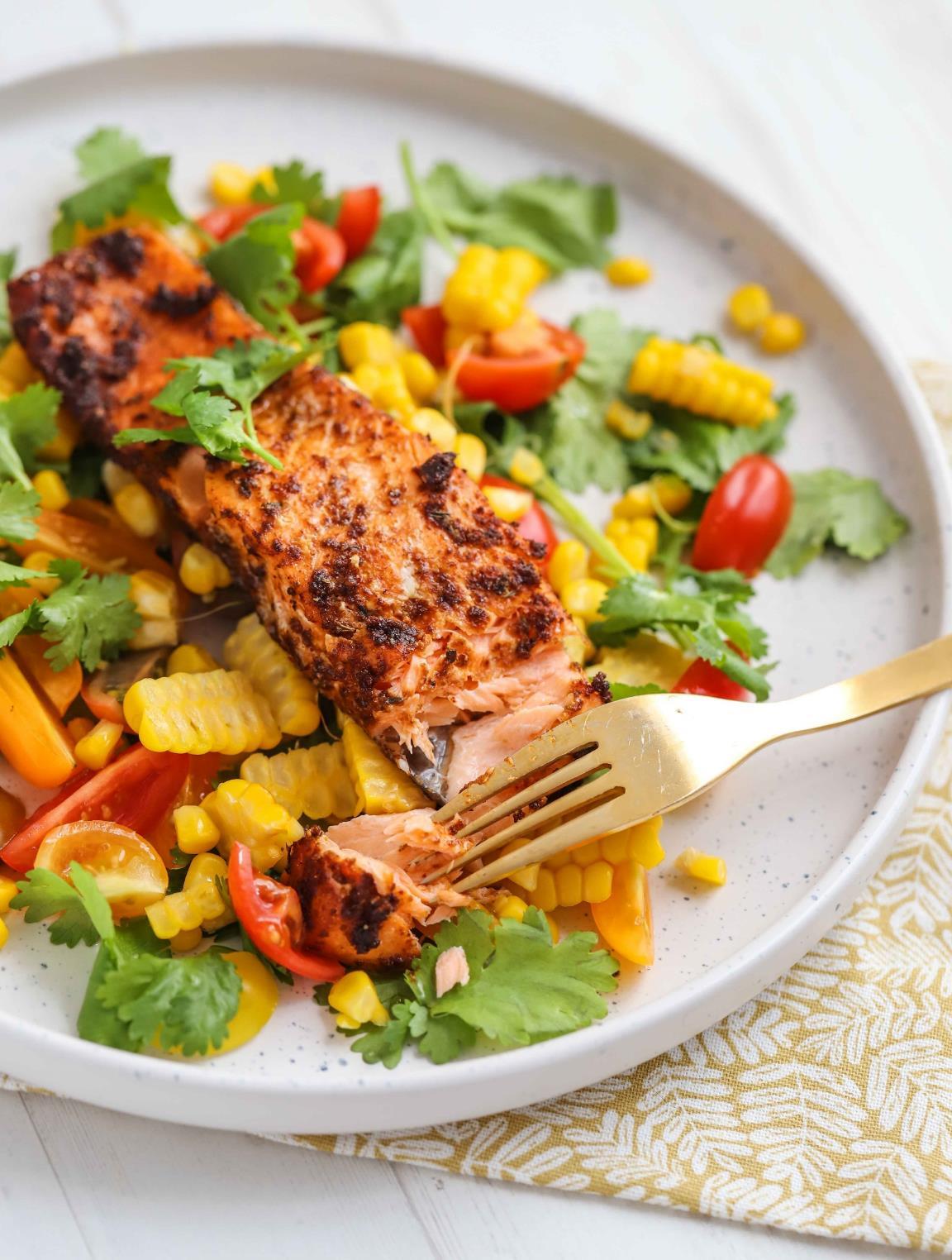 A plate of Cajun-spiced salmon fillet on a bright corn, cherry tomato and coriander salsa